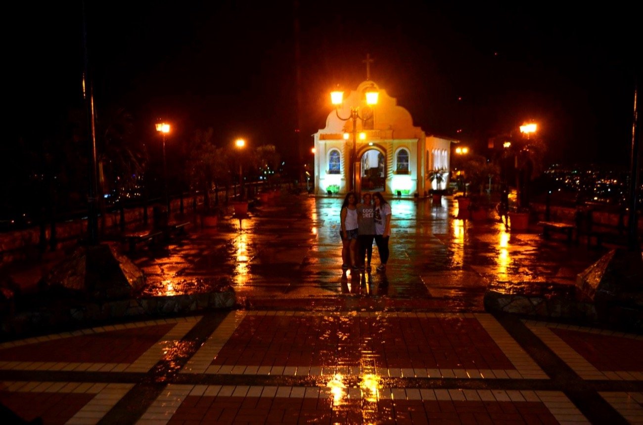 Mariel Cárdenas con sus amigas bajo la lluvia de noche en Guayaquil