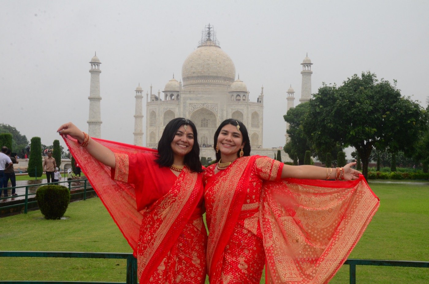 Mariel Cárdenas y una amiga con trajes típicos rojos frente al Taj Mahal