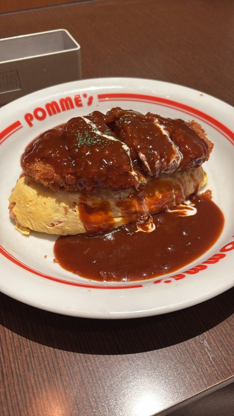 Omurice con salsa demi-glace sobre un plato rojo y blanco, en Osaka