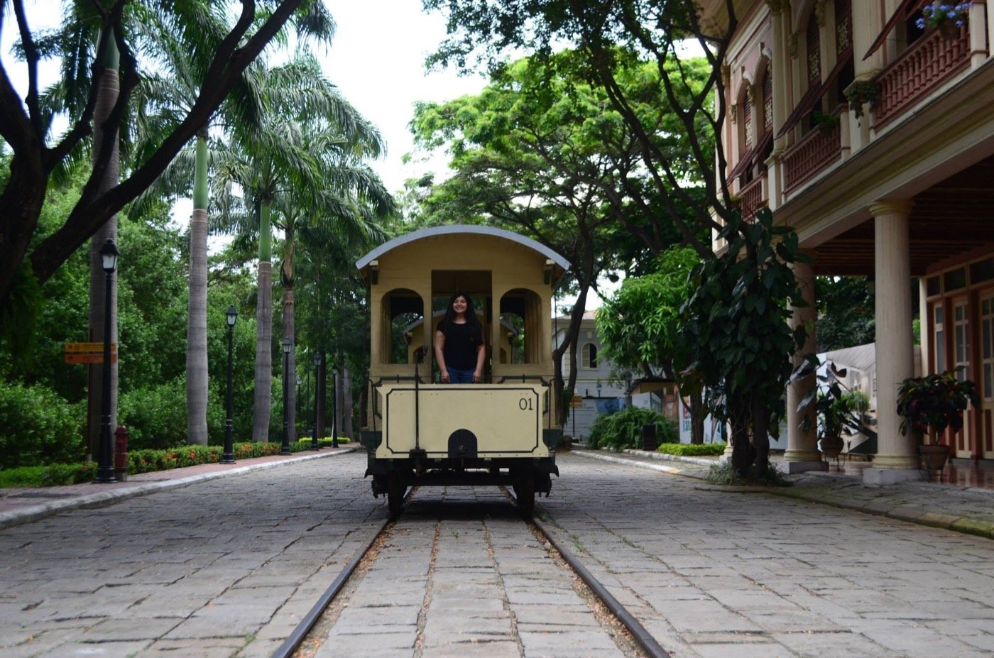 Mariel Cárdenas sobre un tranvía antiguo en un parque de Ecuador