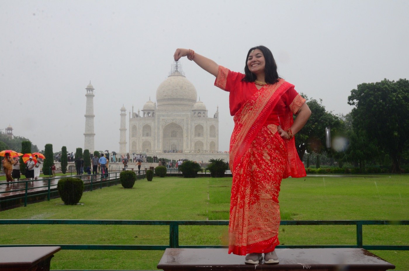 Mariel Cárdenas posando con un traje típico rojo frente al Taj Mahal, en la India