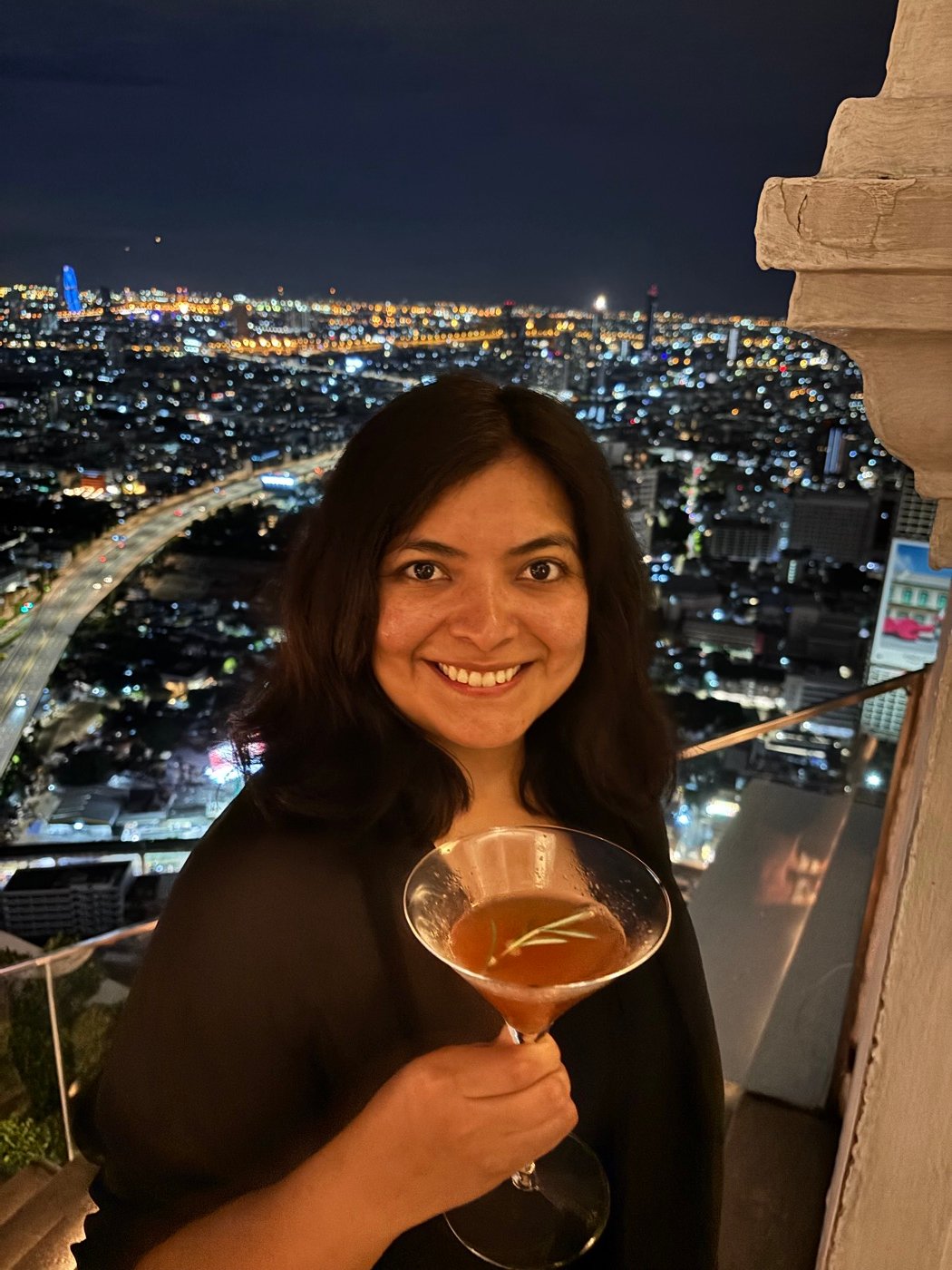 Mariel Cárdenas con un cóctel en un rooftop de Bangkok de noche