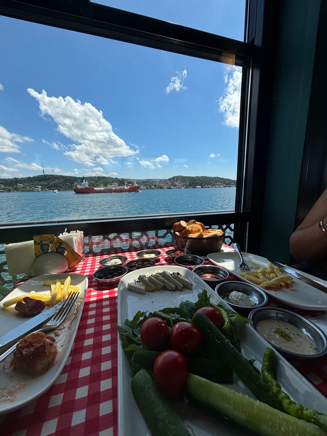 Desayuno turco servido frente a una ventana con vista al Bósforo
