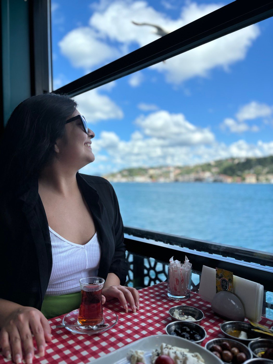 Mariel Cárdenas mirando por la ventana mientras una gaviota vuela cerca, en Estambul