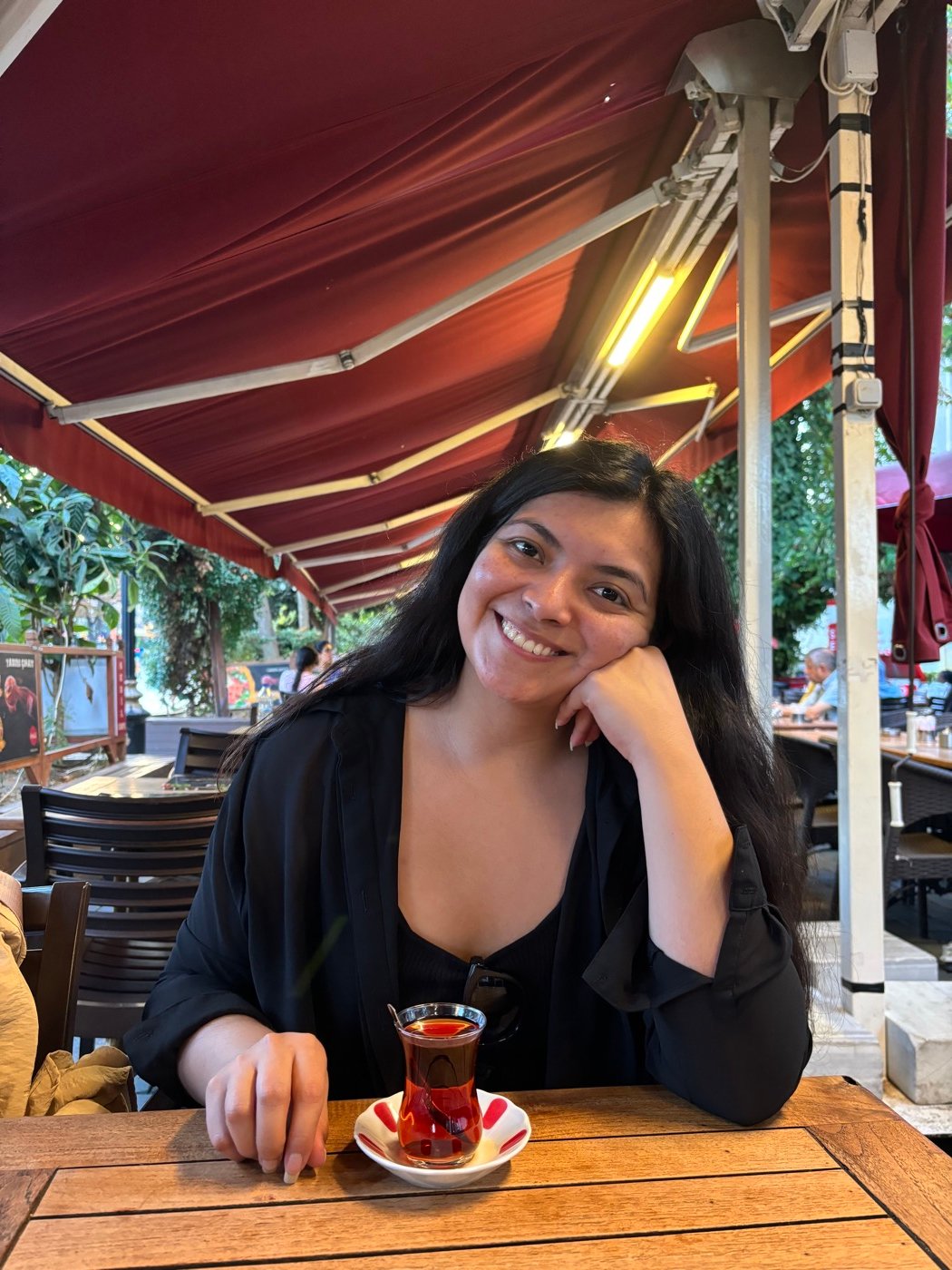 Mariel Cárdenas sonriendo con un vaso de té turco en una terraza de Estambul
